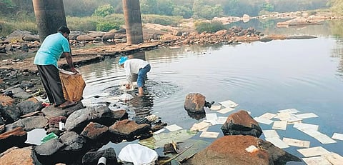 ನದಿಗೆ ಹಾಕಿದ್ದ ಕಸ ತೆಗೆಯುತ್ತಿರುವ ಕುಟುಂಬಸ್ಥರು.