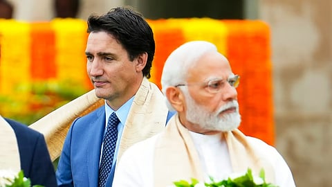 Canada's Prime Minister Justin Trudeau, left, walks past India's Prime Minister Narendra Modi.