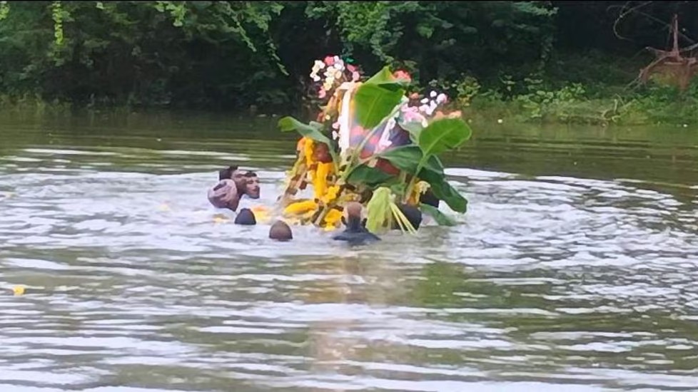 Villagers carry body in neck-deep water
