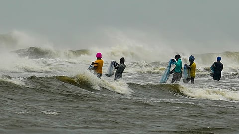 Fishermen move a boat away from the sea amidst an advisory issued by the India Meteorological Department (IMD) not to venture into the sea as a Cyclone Fengal approches.