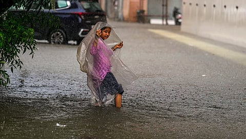 A young woman on a waterlogged road in Chennai.