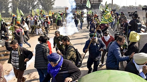 Farmers move away as security personnel fire teargas shells