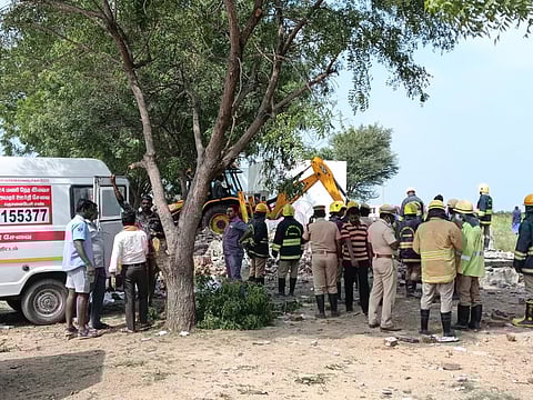 Fire and Rescue service personnel are searching through the debris at the firecracker incident site in Bommaiyapuram village near Sattur