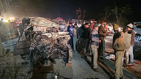 Police personnel and other people at the site after a collision between a bus and a Bolero car, which was carrying devotees to the Maha Kumbh, on a highway in the Meja police station area of Prayagraj, late on Friday night, Feb. 14, 2025.