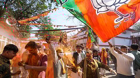BJP supporters celebrate the party's decisive lead in the Delhi Assembly polls as counting of votes is underway, outside the Delhi BJP office.