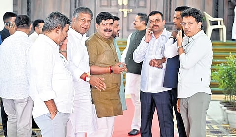 BJP legislators gather outside the House, during the ongoing session, at Vidhana Soudha in Bengaluru on Tuesday.