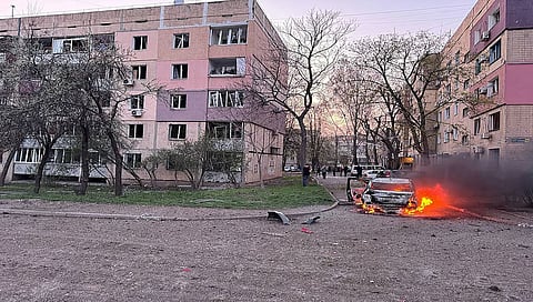 Burning car next to damaged buildings in Kryvyi Rig