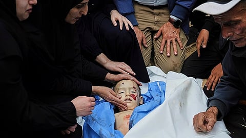Palestinians mourn over the body of Kinan Edwan, 2 years old, killed in an Israeli army airstrike, during his funeral in Khan Younis, southern Gaza Strip, Saturday.