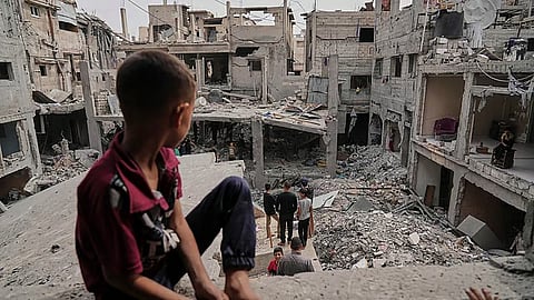 Palestinians inspect the rubble of the Al-Lahham family's home, destroyed by Israeli airstrike