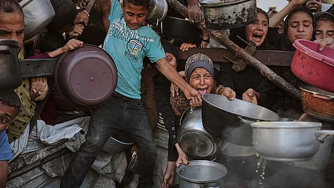 Palestinians struggle to get donated food at a community kitchen