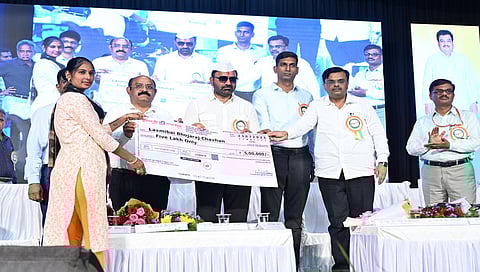 Santosh Lad distributes compensation cheque to a relative of a labourer