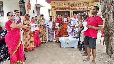 Voters show the enumeration forms given by a Booth Level Officer (BLO) during the ongoing Special Intensive Revision of electoral rolls in Vaishali district, Bihar