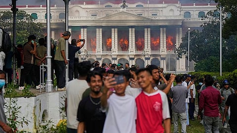 Protesters take selfies at the Singha Durbar, the seat of Nepal's government's various ministries and offices, after it was set on fire