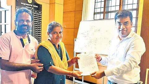 Ramanagara DC Yashwant V Gurukar presents a reward to assistant teacher Shantamma