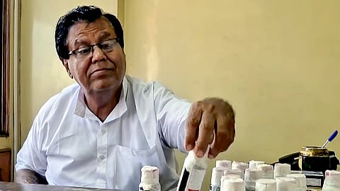 An official looks at bottles of the Coldrif cough syrup after a raid by the Drug and Pharmaceuticals Department officials at Kataria Pharmaceuticals
