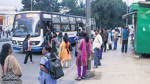 Commuters board a bus a few metres ahead of the bus stop at Balekundri Circle as drivers halt vehicles away from the designated spot.