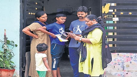 An enumerator collects details from a family during the socio-economic survey