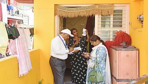 An enumerators collects details from a family as part of the socio-economic survey