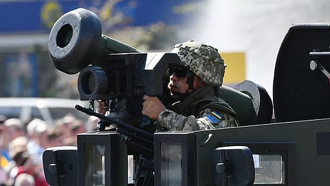 A Ukrainian serviseman rides atop of an APC with Javelin anti-tank missiles during a military parade in Kiev