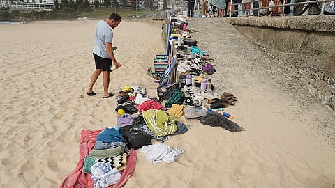 A man looks at belongings stacked up following a shooting the day prior at Sydney's Bondi Beach.