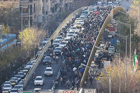 Protesters march on a bridge in Tehran, Iran