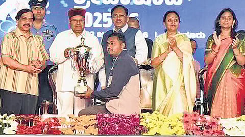 Governor Thaawarchand Gehlot presents the champion trophy to an athlete.