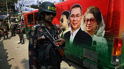 Security personnel stand guard next to a bullet proof bus of BNP chairman Tarique Rahman featured