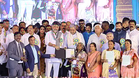 Chief Minister Siddaramaiah and Deputy Chief Minister D K Shivakumar handover title deeds to beneficiaries at ‘Land Guarantee’ convention, in Haveri on Saturday.