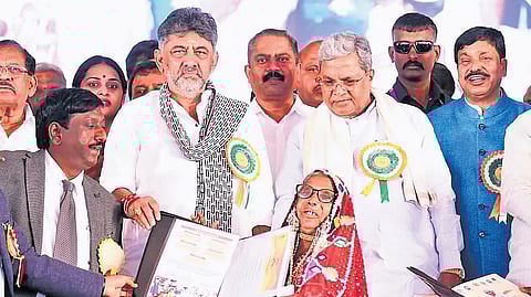 CM Siddaramaiah and Deptuy CM DK Shivakumar distribute title deeds to beneficiaries at the Bhoo Guarantee Samarpana Samavesha in Haveri on Saturday