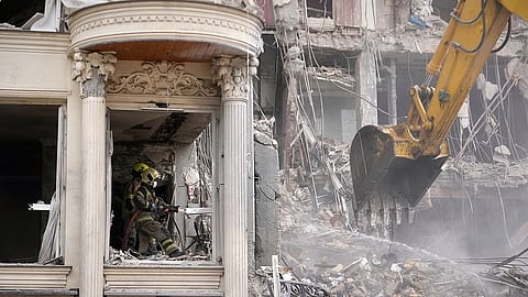Rescue workers and first responders work at a residential building hit in an earlier U.S.-Israeli strike in Tehran, Iran, Monday, March 23, 2026
