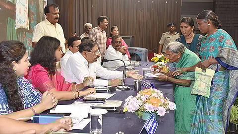 Home Minister Dr G Parameshwara listens to the grievances of an elderly woman in Tumakuru on Wednesday.