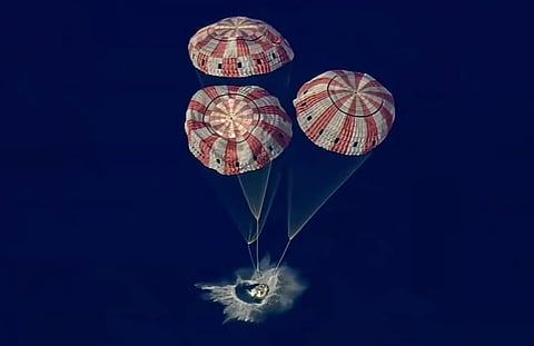 In this image from video provided by NASA, the Artemis II Orion capsule splashes down in the Pacific Ocean