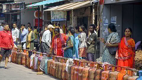 People stand in a queue to refill their gas cylinders