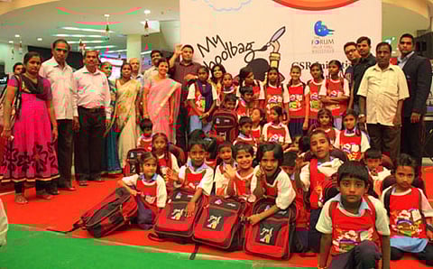 ಮಕ್ಕಳಿಗೆ ಬ್ಯಾಗ್ ವಿತರಿಸುತ್ತಿರುವುದು