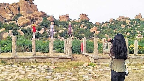 ಸಾಲು ಮಂಟಪದ ಕಂಬಗಳ ಮೇಲೆ ನಿಂತಿರುವ ವಿದೇಶಿ ಪ್ರವಾಸಿಗರು