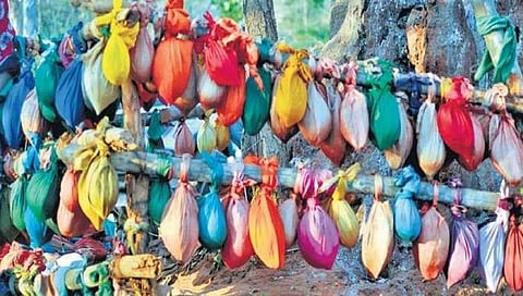 ದೇವಸ್ಥಾನದ ಹಿಂದೆ ತೆಂಗಿನಕಾಯಿಯನ್ನು ಬಟ್ಟೆಯಲ್ಲಿ ಸುತ್ತಿ ನೇತು ಹಾಕಿರುವುದು