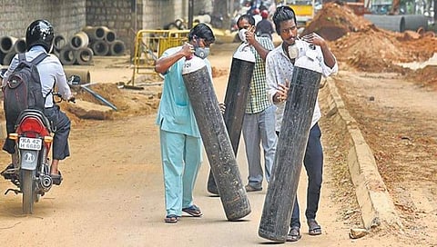 ಬೆಂಗಳೂರಿನ ಖಾಸಗಿ ಆಸ್ಪತ್ರೆಯ ಹೊರಗೆ ನೌಕರರು ಆಕ್ಸಿಜನ್ ಟ್ಯಾಂಕ್ ಒಯ್ಯುತ್ತಿರುವುದು