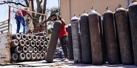 ಆಕ್ಸಿಜನ್ ಸಿಲಿಂಡರ್ ಸಾಗಿಸುತ್ತಿರುವ ಕಾರ್ಮಿಕರು