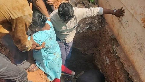 ಗುಂಡಿಗೆ ಬಿದ್ದ ಮಹಿಳೆಯನ್ನು ರಕ್ಷಿಸುತ್ತಿರುವ ಸ್ಥಳೀಯರು.