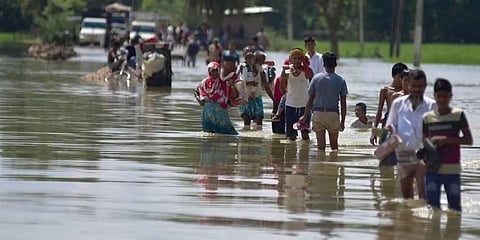 ಅಸ್ಸಾಂ ಪ್ರವಾಹಪೀಡಿತ ರಸ್ತೆಯನ್ನು ದಾಟುತ್ತಿರುವ ಜನರು