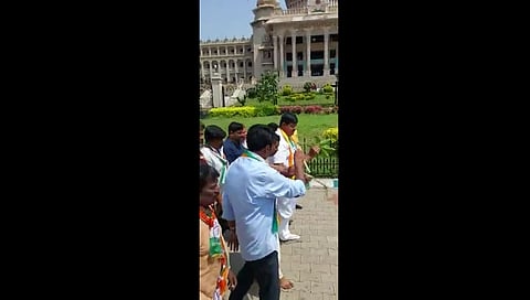 ವಿಧಾನಸೌಧದ ಮುಂಭಾಗ ಗೋಮೂತ್ರ ಸಿಂಪಡಿಸುತ್ತಿರುವ ಕಾಂಗ್ರೆಸ್ ಕಾರ್ಯಕರ್ತರು.