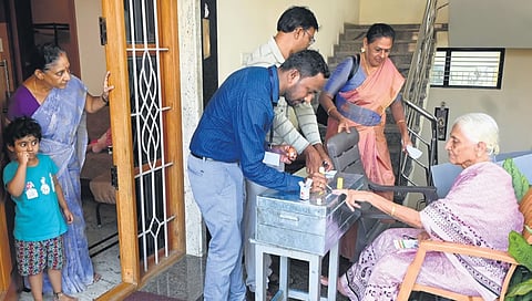 ಶನಿವಾರ ಬೆಂಗಳೂರಿನಲ್ಲಿ ಹಿರಿಯ ನಾಗರಿಕರೊಬ್ಬರು ತಮ್ಮ ಮನೆಯಿಂದಲೇ ಮತದಾನ ಮಾಡಿದರು. ಚುನಾವಣಾ ಅಧಿಕಾರಿಗಳು ಮತ್ತು ಕುಟುಂಬ ಸದಸ್ಯರು ಇದ್ದಾರೆ.