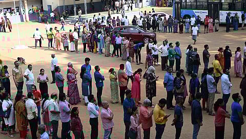People stand in queue at a school to vote at Rajarajeshwari Nagar, Bengaluru Rural constituency.