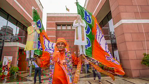 A BJP supporter during the celebration of the party's lead amid the counting of votes for the Lok Sabha elections, at the party office, in New Delhi, Tuesday, June 4, 2024