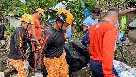 Rescuers carry a body after a landslide triggered by Tropical Storm Trami struck homes in Talisay, Batangas province, Philippines, Saturday, Oct. 26, 2024.
