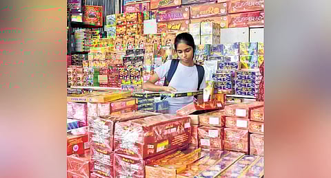 A girl selects firecrackers at a temporary stall set up in Basavangudi, on Monday