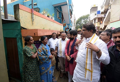 Opposition leader R Ashok and party leaders discuss with people who received Waqf board notices at Gundurao nagar in Mysuru on Monday.