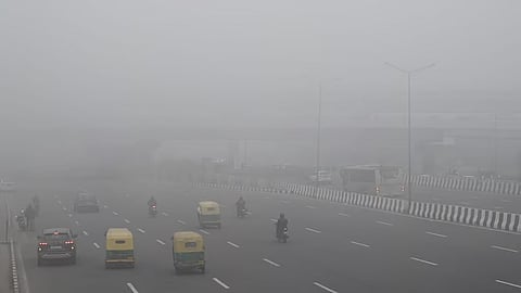 Commuters step out on a cold foggy morning in New Delhi on Friday