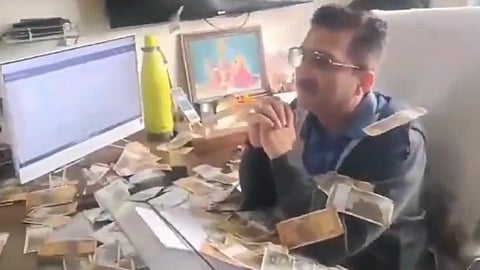 angry villagers throwing bundles of cash allegedly at a government officer