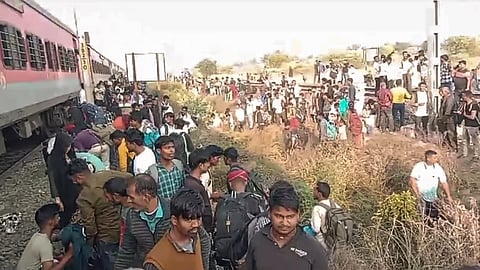 People gather at the site following the death of several passengers after they stepped down due to a rumour of fire and were run over by another train passing on the adjacent tracks, in North Maharashtra's Jalgaon district.